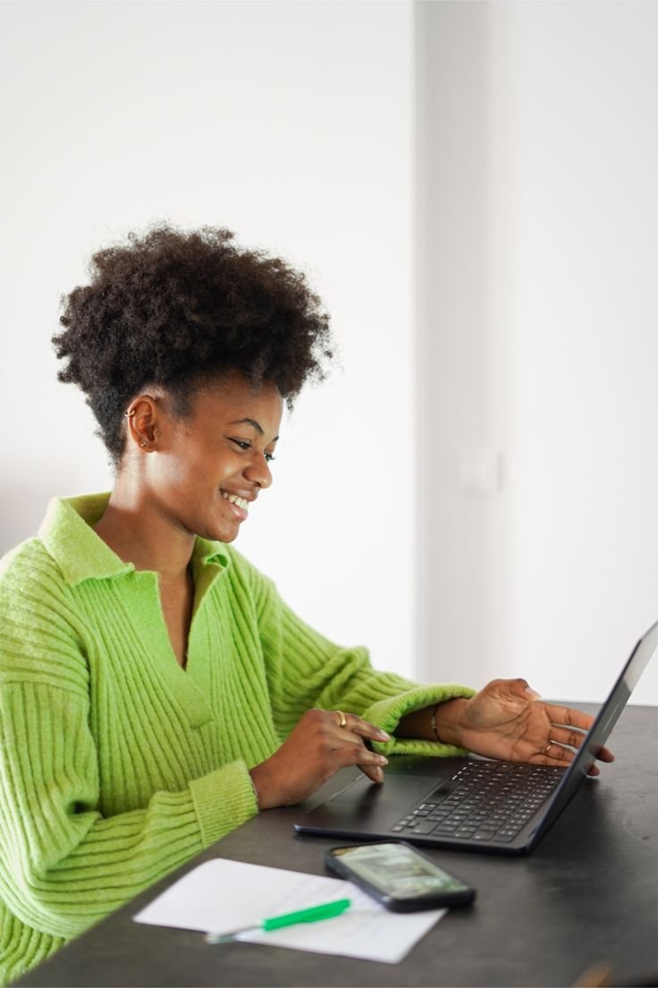 A young entrepreneur smiling while working on her laptop